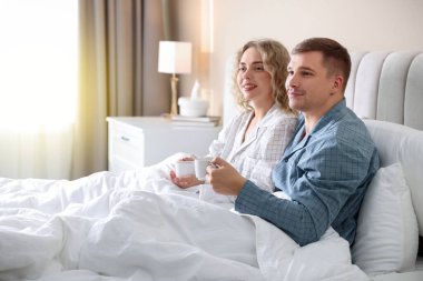 Hoş bir çift evde sıcak içeceklerin tadını çıkarıyor.