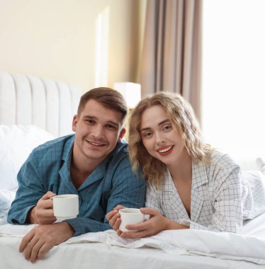 Hoş bir çift evde sıcak içeceklerin tadını çıkarıyor.