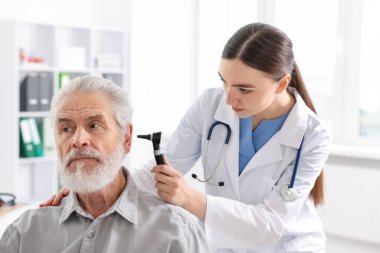 Duyma testi. Klinikte hastanın kulağını yıldız falıyla muayene eden doktor.