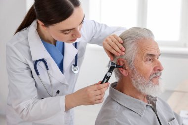 Duyma testi. Klinikte hastanın kulağını yıldız falıyla muayene eden doktor.