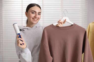 Kadın evde pamuklu bezle kazak temizliyor.