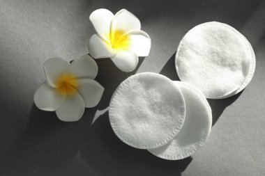 Gri arka planda temiz pamuk pedler ve çiçekler, düz yatıyordu.