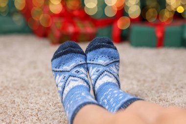 Evinde yerde mavi çoraplar giyen bir kadın, yakın plan.
