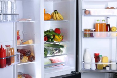 Farklı taze gıda ürünleri olan modern buzdolabı, yakın plan.