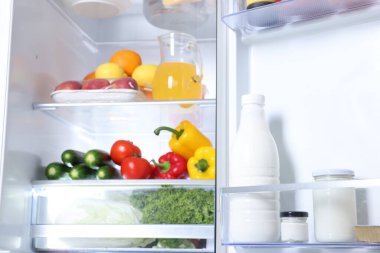 Farklı taze gıda ürünleri olan modern buzdolabı, yakın plan.