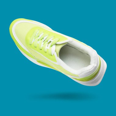 Mavi eğimli arka planda havada parlak bir spor ayakkabı