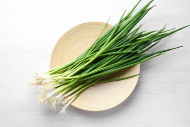 Beyaz ahşap masada taze taze taze soğanlar, üst manzara.