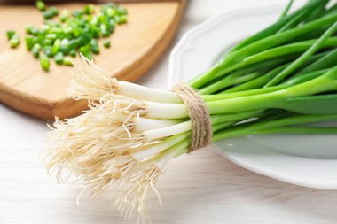 Taze taze taze soğanlar beyaz ahşap masada, yakın plan.