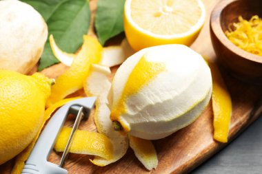 Lezzetli taze limonlar, soyucu ve yapraklar siyah masada, yakın plan