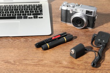 Ahşap arka planda profesyonel fotoğrafçı ekipmanı, yakın plan.