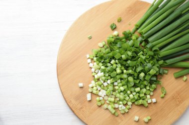 Beyaz ahşap masada taze yeşil soğan kes, üst manzara. Metin için boşluk