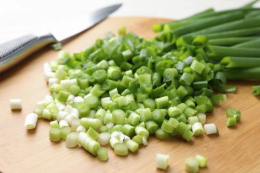 Taze yeşil soğan ve bıçağı masaya yakın çekim yap.