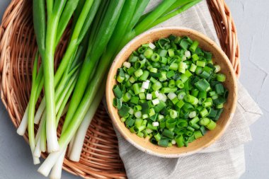 Gri masada taze taze soğan var, üst tarafta.