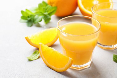 Taze portakal suyu, nane ve meyveler ışık masasında, yakın plan.