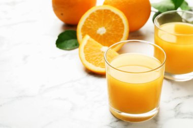Taze portakal suyu ve beyaz mermer masada meyveler, yakın plan. Metin için boşluk