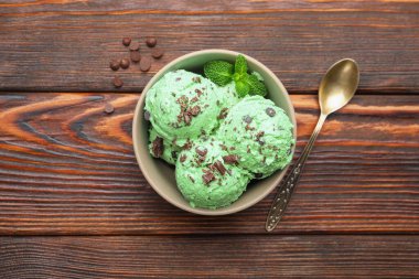 Nefis naneli çikolata parçalı dondurma ve kaşık ahşap masada.