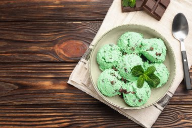 Tahta masa üzerinde yaprak ile servis edilen naneli çikolatalı dondurma. Metin için boşluk