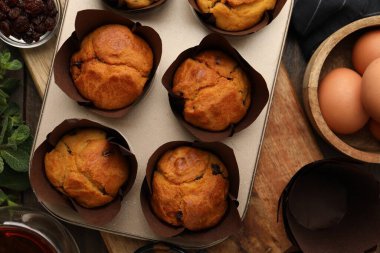 Kuru üzümlü lezzetli kekler, nane şekeri, yumurta ve çay ahşap masada, düz uzanmış.