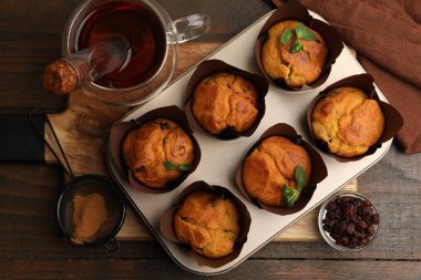 Kuru üzümlü lezzetli çörekler, nane şekeri ve ahşap masa üzerinde çay.