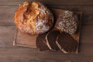 Ahşap masada farklı ekmek türleri, üst görünüm