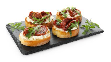 Krem peynirli lezzetli bruschettalar, güneşte kurutulmuş domatesler ve beyaz üzerine izole edilmiş roka.