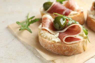 Krem peynirli, jambonlu, yeşil zeytinli ve roka soslu nefis bruschetalar, yakın plan. Metin için boşluk