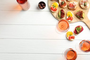 Beyaz ahşap masada servis edilen prosciutto ve gül şarabı ile nefis bruschetalar, düz yatak. Metin için boşluk