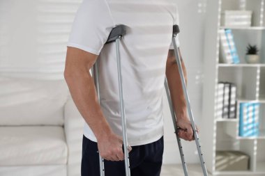 Evde koltuk değneği kullanan bir adam, yakın plan.