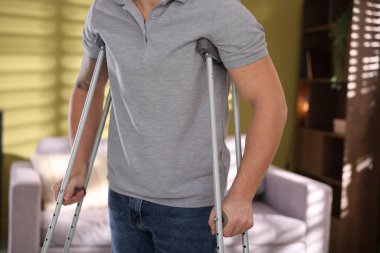 Evde koltuk değneği kullanan bir adam, yakın plan.