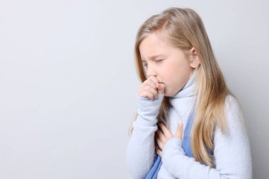 Küçük kız arka planda öksürüyor, mesaj için yer var. Soğuk Semptom