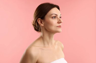 Pembe arka planda güzel bir kadının portresi.