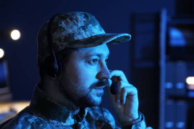 Askerlik. Kulaklıklı asker gece ofiste çalışıyor, mesaj için yer var.