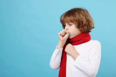 Küçük çocuk açık mavi arka planda öksürüyor, mesaj için yer var. Soğuk Semptom