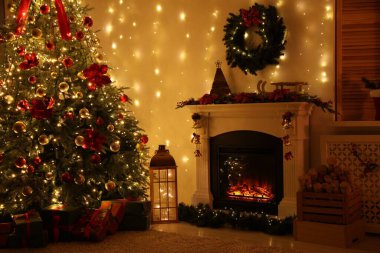 Güzel bir şömine, Noel ağacı ve karanlık odada şenlikli bir dekor. İç tasarım