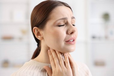 Evde boğazı ağrıyan bir kadın, yakın plan. Soğuk Semptom