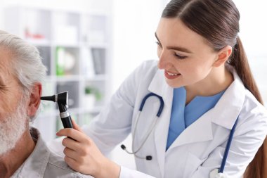 Duyma testi. Klinikte hastanın kulağını yıldız falıyla muayene eden doktor.