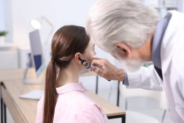 Duyma testi. Klinikte hastanın kulağını yıldız falıyla muayene eden doktor.