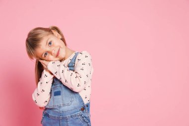 Pembe arka planda küçük şirin bir kızın portresi. Metin için boşluk