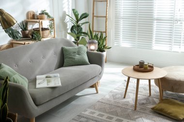 Kanepesi ve çiçekleri olan şık bir oturma odası. İç tasarım