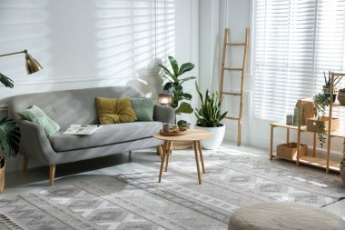 Kanepesi ve çiçekleri olan şık bir oturma odası. İç tasarım