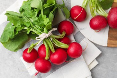 Açık gri masada bir avuç taze turp, düz yatıyordu.