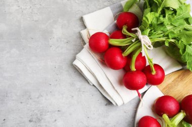 Açık gri masada bir avuç taze turp, düz yerde. Metin için boşluk