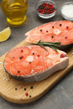 Baharatlı, limonlu ve yağlı somon filetosu. Gri desenli masa, yakın plan.