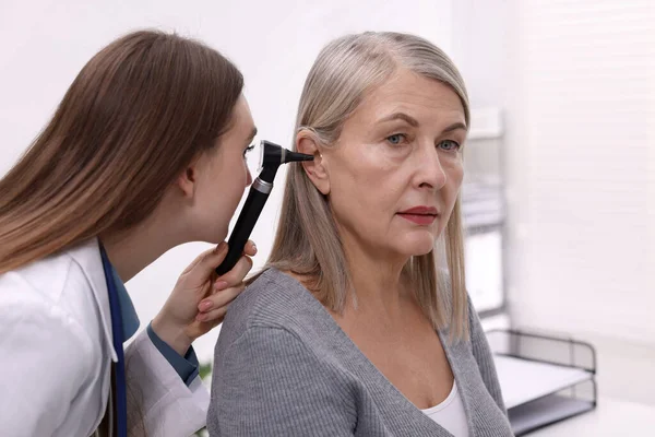 Duyma testi. Klinikte hastanın kulağını yıldız falıyla muayene eden doktor.