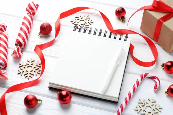 Yeni yıl hedefleri. Boş planlayıcı, kalem ve beyaz ahşap masada şenlikli bir dekor.