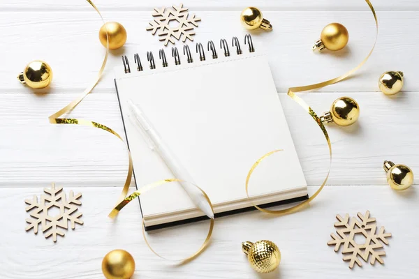 Yeni yıl hedefleri. Boş planlayıcı, kalem ve beyaz ahşap masada şenlikli bir dekor.