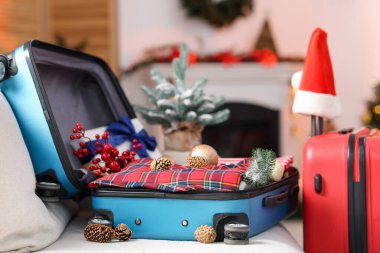 Elbiseli bavullar ve kapalı koltukta şenlik dekoru, yakın plan. Noel tatili