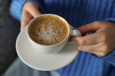 Kapalı mekanda bir fincan aromatik kahveli kadın, yakın plan.