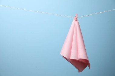 Açık mavi arka planda ipe asılı güzel bir pamuk mendil. Metin için boşluk