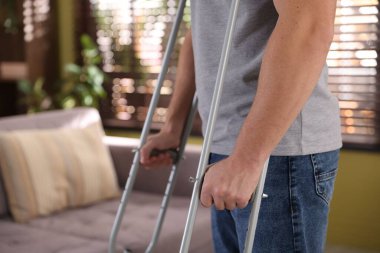 Evde koltuk değneği kullanan bir adam, yakın plan. Metin için boşluk